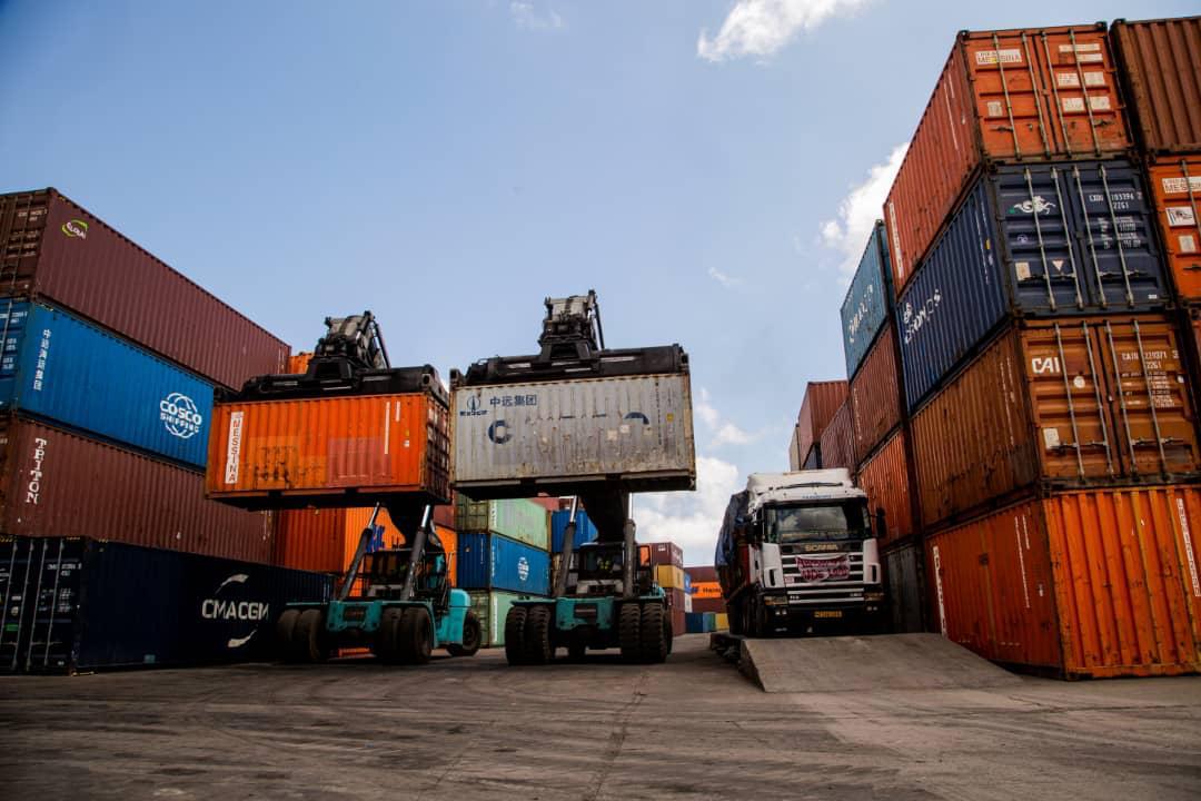 Reach stackers lifting containers onto a waiting truck